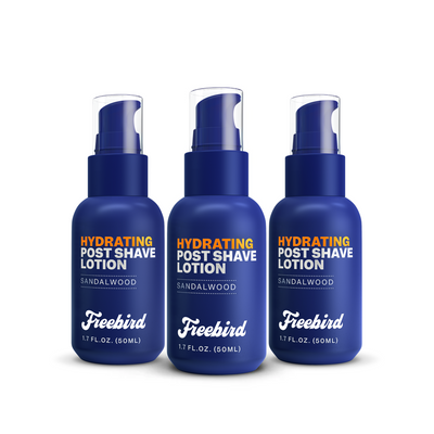 Three 1.7 fl oz blue bottles of Freebird Hydrating Post-Shave Lotion with sandalwood scent to reduce dryness after shaving.