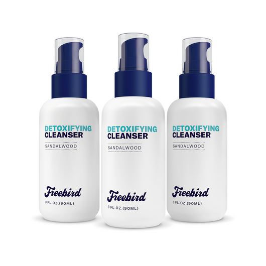 Three bottles of Freebird Detoxifying Bald Head Cleanser with blue pumps rest on a white background for an effective detox.